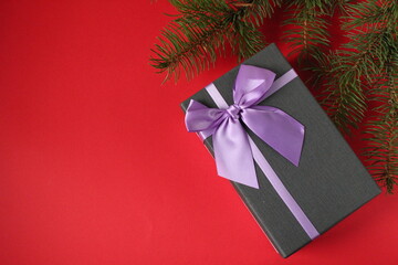 new year's Christmas background gift gift box and branch of a Christmas tree pine trees on a red background with space for the text copy space