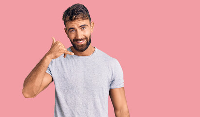 Young hispanic man wearing casual clothes smiling doing phone gesture with hand and fingers like talking on the telephone. communicating concepts.