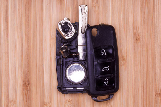 Broken Or Damaged Remote Key Fob On Wooden Background. Remote Key Fob Of Any Vehicle Car Locksmith Service.