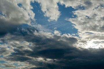 sun hid behind the clouds against the blue sky with blurry background, used as a background or texture, soft focus