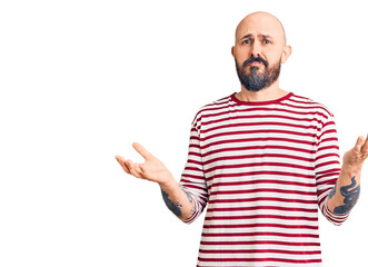 Young handsome man wearing casual clothes clueless and confused expression with arms and hands...