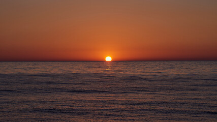 Beautiful red pink orange dawn on the sea without waves