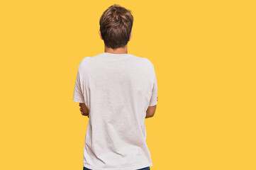 Handsome caucasian man wearing casual clothes and glasses standing backwards looking away with...
