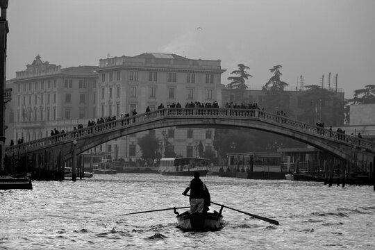 Fototapeta Venice, Italy, December 28, 2018 evocative black and white image of gondolas moving in a canal