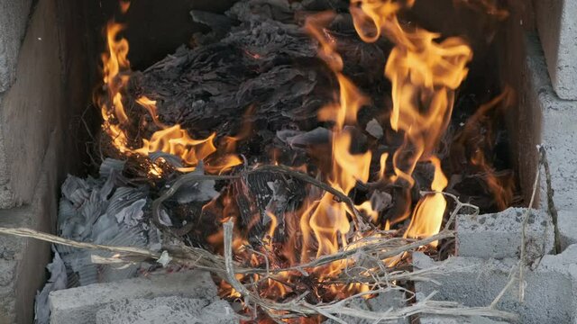 Paper and weeds burning in bonfire close up