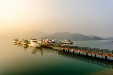 Obraz premium Beautiful sun rise scene of boats at pier at Sun Moon Lake, Taiw