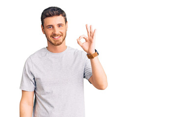 Fototapeta premium Handsome young man with bear wearing casual tshirt smiling positive doing ok sign with hand and fingers. successful expression.