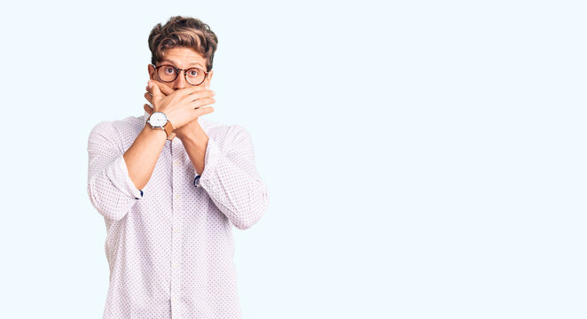 Young handsome man wearing business clothes and glasses shocked covering mouth with hands for mistake. secret concept.