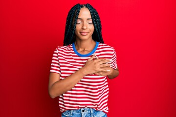 Beautiful hispanic woman wearing casual clothes smiling with hands on chest with closed eyes and grateful gesture on face. health concept.