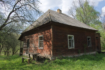 Obraz premium An abandoned wooden house in the forest. An old wooden house. Construction with a slate roof.