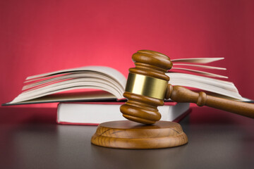 Wooden gavel and books on wooden surface
