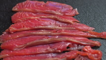 Close up shot of smoothly rotating salmon, Sushi cooking process - Philadelphia, burning fire smoking fresh raw red tuna salmon eel