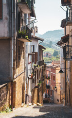 Narrow street in old town, Europe. Downtown in mountains, Spain. Facade of ancient houses. Historical cityscape. Empty town. Quarantine pause in Spain. Residential district with no people. Old centre.