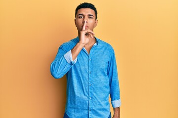 Young arab man wearing casual clothes asking to be quiet with finger on lips. silence and secret concept.