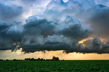 Fototapeta premium Ominous storm clouds over farmland at sunset