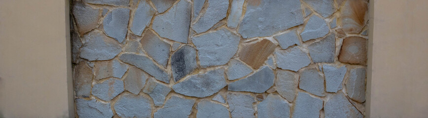 Panorama of the natural stone wall. Beige textured wall background for interior design