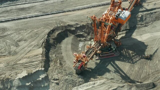 Aerial view of bucket wheel excavator in process of mining natural resource. Heavy industry.