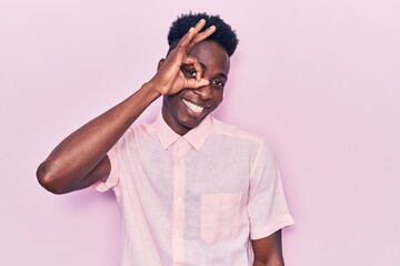 Obraz premium Young african american man wearing casual clothes smiling happy doing ok sign with hand on eye looking through fingers