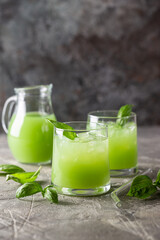Cold basil lemonade refreshing summer drink on gray background