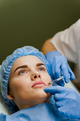 Close-up lips augmentation injections for attractive girl. Plastic surgeon does injection in lip in...