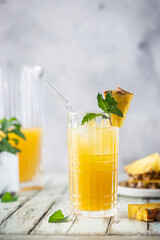 Fresh pineapple cocktail in the glass with ice and mint, summer drink