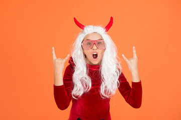 let the party begin. carnival costume party. trick or treat. celebrate the holidays. happy halloween devil girl. teenage child in imp horns. cheerful kid with white hair in fanny glasses