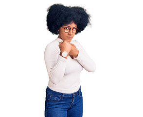 Young african american girl wearing casual clothes and glasses ready to fight with fist defense gesture, angry and upset face, afraid of problem