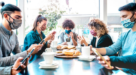 Millenial people using mobile smart phones at coffee bar - New normal lifestyle concept with...