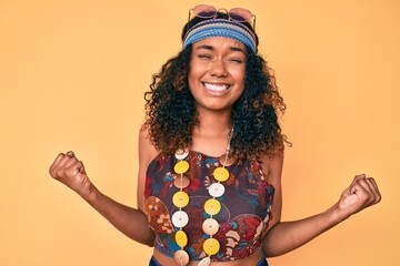 Young african american woman wearing bohemian and hippie style very happy and excited doing winner...