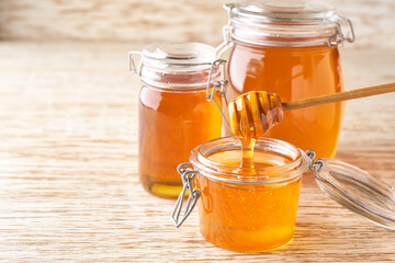 open jar of  sweet honey on a white  table, selective focus.