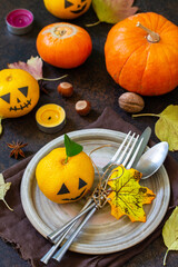 Halloween wooden table setting with pumpkins and tangerines.