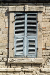 Old window with wooden shutters in brick wall  