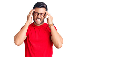 Young hispanic man wearing casual clothes and glasses suffering from headache desperate and stressed because pain and migraine. hands on head.
