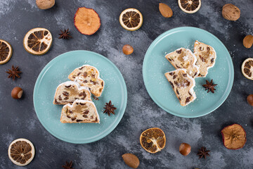 Christstollen, traditonal christmas cake with nuts, raisons, marzipan on a blue background, empty space for text