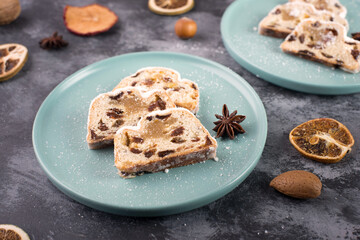Christstollen, traditonal christmas cake with nuts, raisons, marzipan on a blue background, empty space for text