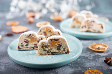 Christstollen, traditonal christmas cake with nuts, raisons, marzipan on a blue background, empty space for text