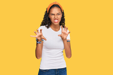 Young african american girl wearing casual clothes smiling funny doing claw gesture as cat,...