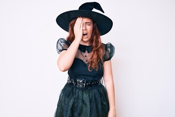Young beautiful woman wearing witch halloween costume yawning tired covering half face, eye and mouth with hand. face hurts in pain.