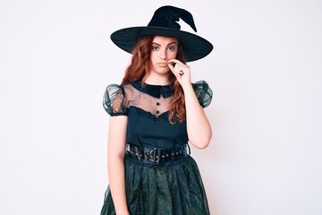 Young beautiful woman wearing witch halloween costume mouth and lips shut as zip with fingers. secret and silent, taboo talking