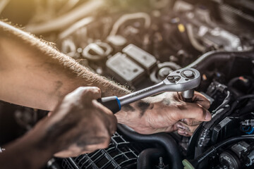 Fototapeta na wymiar Auto mechanic working and repair on car engine in mechanics garage. Car service.