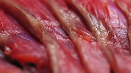 Close up shot of smoothly rotating salmon, Sushi cooking process - Philadelphia, burning fire smoking fresh raw red tuna salmon eel. Makro