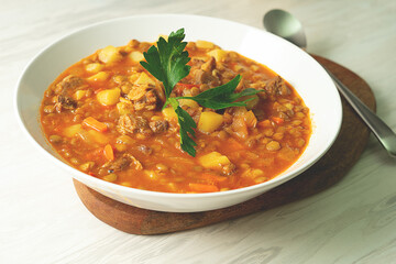 Lentil soup on a wooden board in a white plate