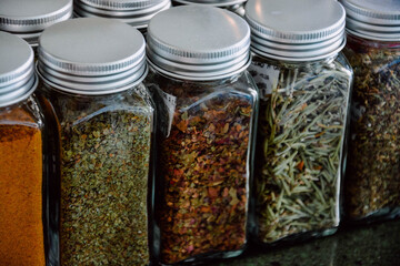 Jars with spices in cupboard