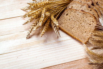 Whole wheat bread. Fresh loaf of rustic traditional bread with wheat grain ear or spike plant on...