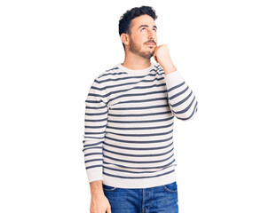 Young hispanic man wearing casual clothes with hand on chin thinking about question, pensive expression. smiling and thoughtful face. doubt concept.