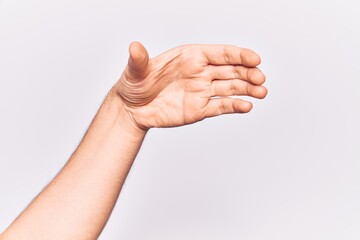 Fototapeta na wymiar Close up of hand of young caucasian man over isolated background holding invisible object, empty hand doing clipping and grabbing gesture