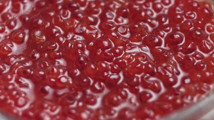 Red Caviar rotated over black background. Close-up salmon caviar rotation. Delicatessen. Texture of caviar. Seafood. 4K UHD video