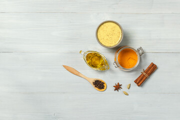 Golden milk, turmeric and spices for cooking on a light wooden background. top view with space