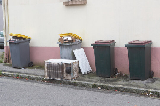 Garbage bin and left-behind fridge in a street in Brest