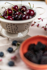 Cherries in a strainer on a pink background